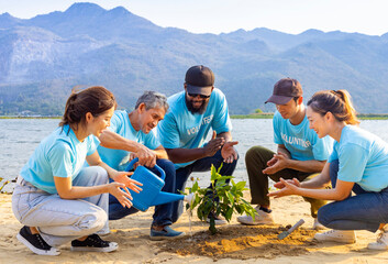 Team of young and diversity volunteer worker group enjoy charitable social work outdoor in tree forest planting NGO work for fighting climate change and global warming in coastline habitat project - obrazy, fototapety, plakaty