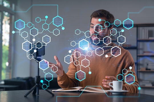 Happy man is making video blog using smartphone on a tripod explaining, teaching, master class people in room. Concept of online stream, business education, conference call. Blockchain hologram