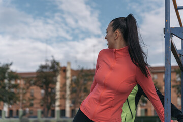 Young female athlete stretching quadriceps femoris on the running track. Girl athlete looking...