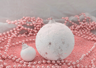 White Christmas balls on a pink background