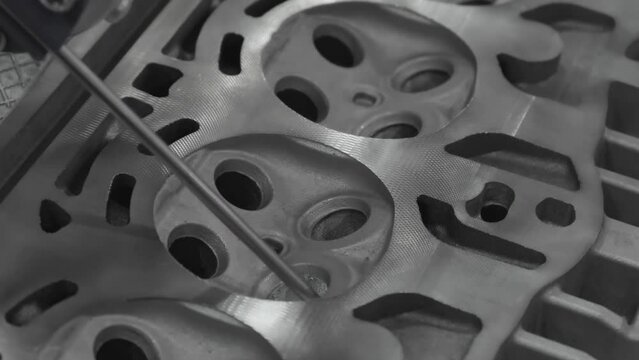 CMM machine measuring dimension at the valve position on the cylinder head parts . The quality control of automotive parts with multi axis CMM machine.