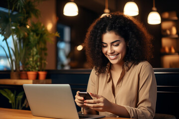 Smiling woman sitting at a table with a laptop and cell phone. Generative AI