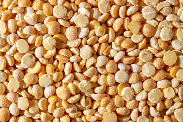 Uncooked Polished Split Peas Background. A Culinary Canvas of Dry Yellow Peas, Creating a Lively and Textured Background for Gourmet Cooking. Scattered Raw Polished Peas. Healthy Eating Ingredients
