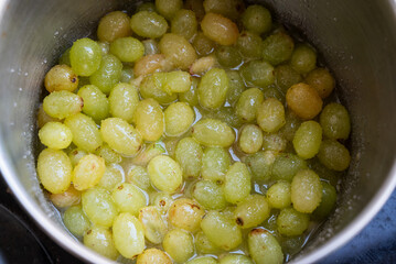 Fresh Green grapes, boiling in a pot with sugar, the first step in the process of making homemade...