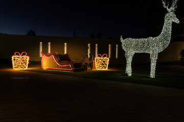 Malaga, Christmas lights, little girl illuminated by Christmas decorations, night photo, gifts and sleigh