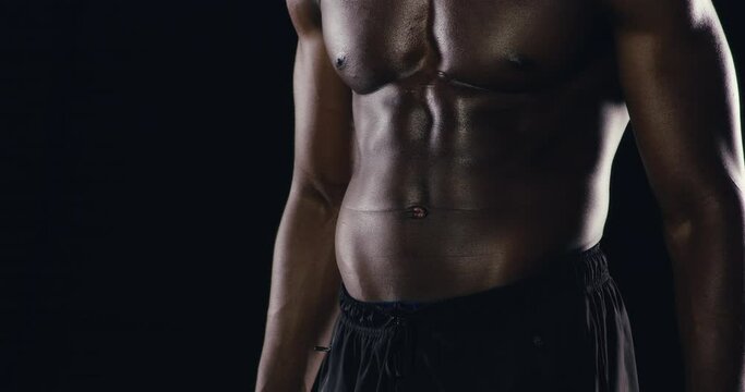 Bodybuilder, man and abdomen for fitness progress, lose weight and muscle, wellness or abs in studio. Person with stomach zoom of workout, training or exercise results for sports on black background
