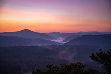 Fototapeta na wymiar Landscape shot in sunrise, cold winter landscape from a sandstone rock in the middle of the forest. Pure nature in the morning from a viewpoint, the Schlüsselfelsen in the Palatinate Forest, Germany