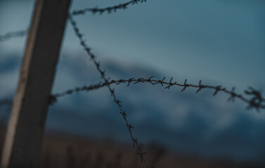 Barbed wire fence on mountains background