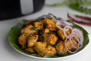 Crispy golden air fried chicken on a plate, deliciously seasoned and served fresh