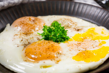 Fried eggs and bread for breakfast on a gray background.