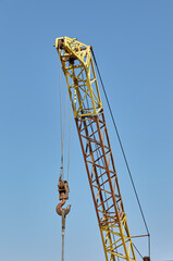 Detail from a floading cargo crane over blue sky background. Boom crane part of mobile crane using to heavy lifting and move object in many industry such as construction, transportation, erection etc