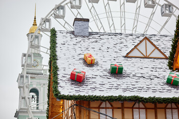 The roof of House Decorated for the Christmas in Europe city. Facade of house for the Christmas Holidays against the backdrop of a ferris wheel