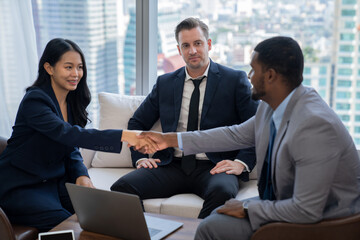 Portrait of young beautiful business shaking with african businessman at office. Businessman making handshaking representing unity, partnership, corporation, joining, collaboration. Ornamented.