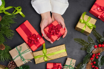 Woman is packing gifts, the pre-holiday bustle and preparations for Christmas. Gifts wrapped in...