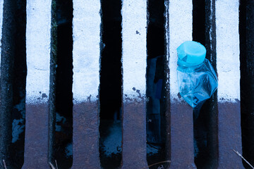 Plastic bottle in a sewer grate