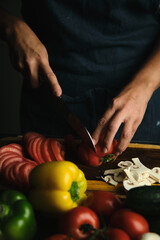 close-up of the cook's hands slicing tomatoes