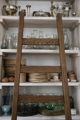 Wooden ladder and kitchen utensils on a shelf