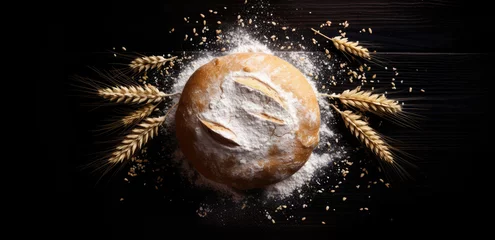 Cercles muraux Boulangerie single bread in the center of the images with wheat whistle on a black wood background.