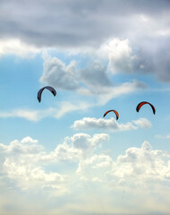 kitesurf  deporte acuático con movimientos con el viento en Tarifa  con un cielo azul con nubes 