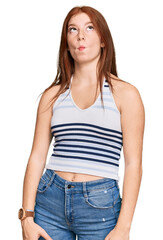 Obraz premium Young read head woman wearing casual clothes making fish face with lips, crazy and comical gesture. funny expression.