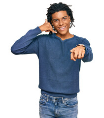 Young african american man wearing casual winter sweater smiling doing talking on the telephone...