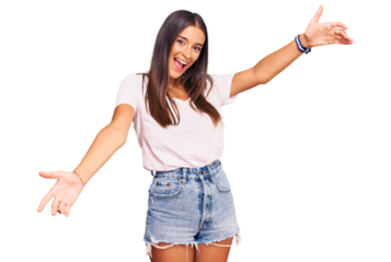 Young hispanic woman wearing casual white tshirt looking at the camera smiling with open arms for hug. cheerful expression embracing happiness.