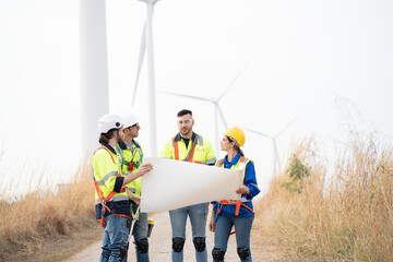 Group of male and female engineer working at wind turbines farm, discussing and inspecting quality...