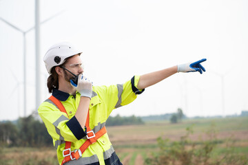 Male engineer using radio communication at windmill field farm. Male engineer working at at wind...