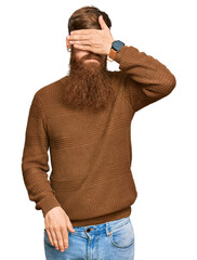 Young irish redhead man wearing casual clothes and glasses covering eyes with hand, looking serious...