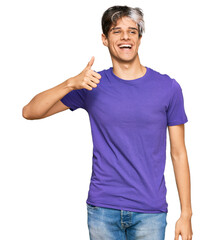 Young hispanic man wearing casual clothes smiling happy and positive, thumb up doing excellent and approval sign