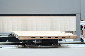 Wood boards on a woodworking machine in a modern furniture factory, woodworking industrial concept...
