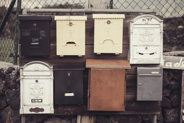 Mailboxes in a row on a metal fence. Vintage style.
