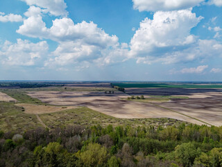 Beautiful blue sky over woodland, aerial view. Agricultural land.