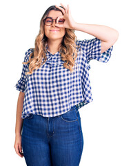 Fototapeta premium Young caucasian woman wearing casual clothes doing ok gesture with hand smiling, eye looking through fingers with happy face.