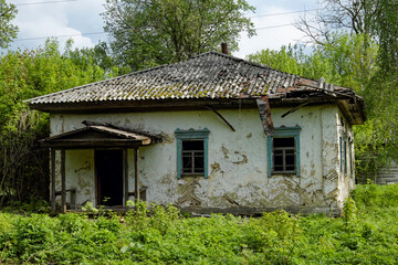 Fototapeta na wymiar A house in a state of disrepair, with a collapsing roof and peeling paint, is captured in the photo.