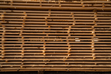 Stacked wooden boards at a outdoor lumber warehouse in a woodworking industry. Stacks with pine lumber. Folded edged board. Wood harvesting shop.