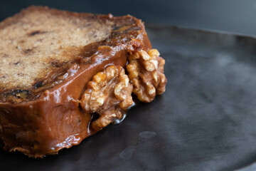 a slice of Chocolate cake topped with walnuts
