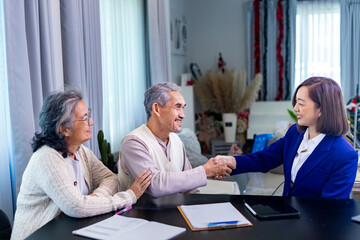 Asian senior couple handshaking the lawyer after finish financial contract and insurance health care benefit for retirement home visit service by professional consultant