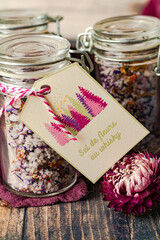 Pots en verre contenant du sel aromatis&eacute; au whisky et fleurs s&eacute;ch&eacute;es. 