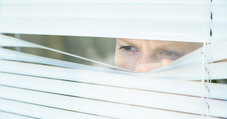 Curious woman peeking through window blinds, close up shot. - 687539449