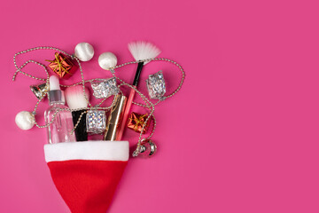 Christmas cosmetics background with Santa's hat, skincare essentials, and gift boxes. Xmas theme for facial care and treatment, featuring brushes, makeup, and cosmetic items