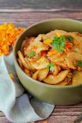 Bol de salade de rondelles de courgette parsem&eacute; de persil accompagn&eacute; d'oeillet d'inde.