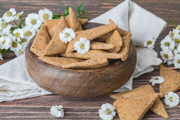 Bol en bois contenant des crackers en forme de triangle