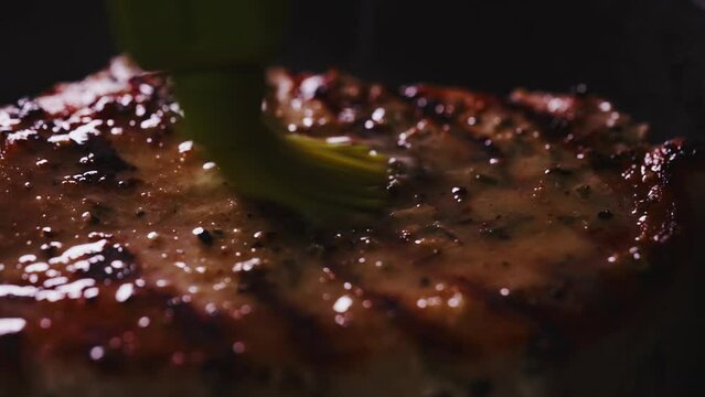 Tomahawk steak is smeared with butter while it is preparing.