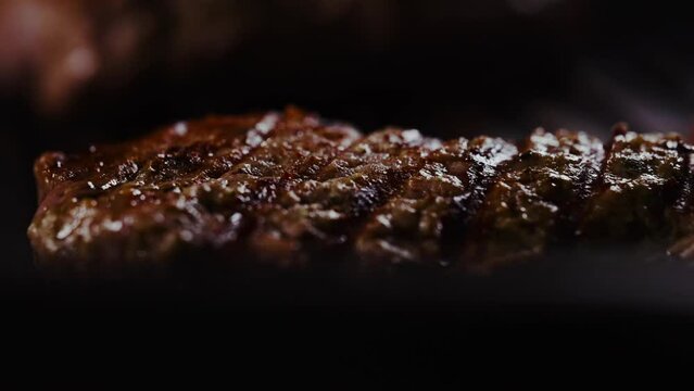 Seasoned tomahawk steak is cooked in a frying pan.