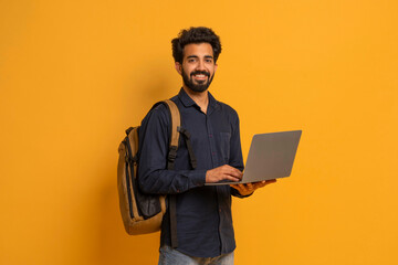 Portrait Of Young Indian Male Student With Backpack And Laptop - obrazy, fototapety, plakaty