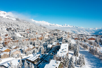 drone view of the ski resort of Crans Montana covered by snow in winter  - 687546473