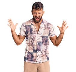 Young hispanic man wearing summer clothes celebrating mad and crazy for success with arms raised...