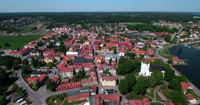 Aerial Panning Shot Of Aisleless Church And Houses In Residential City By Lake On Sunny Day - Mariefred, Sweden