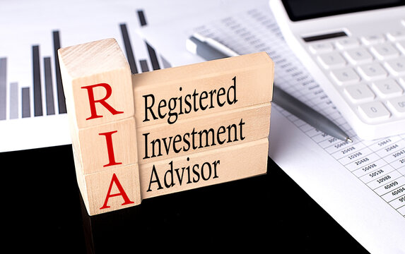 Word RIA REGISTERED INVESTMENT ADVISOR made with wood building blocks, business concept